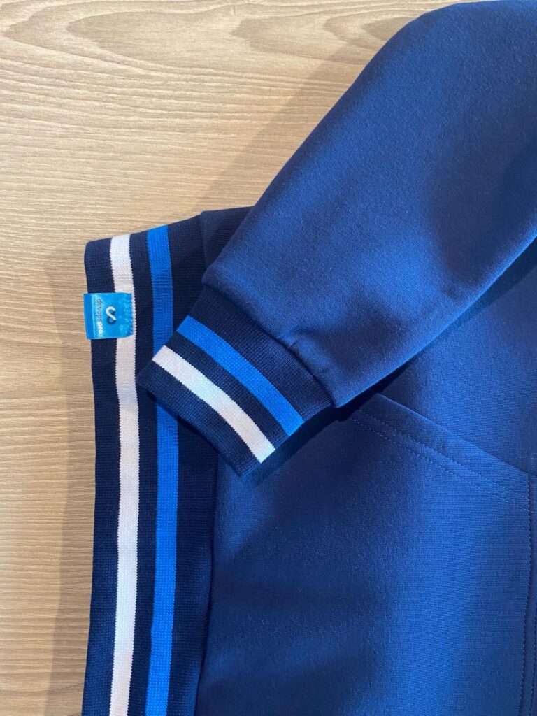 Detailed view of sleeve and pocket on Dataminer hoodie with striped ribbing and logo tag